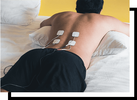 A man using electric stimulation therapy on his back